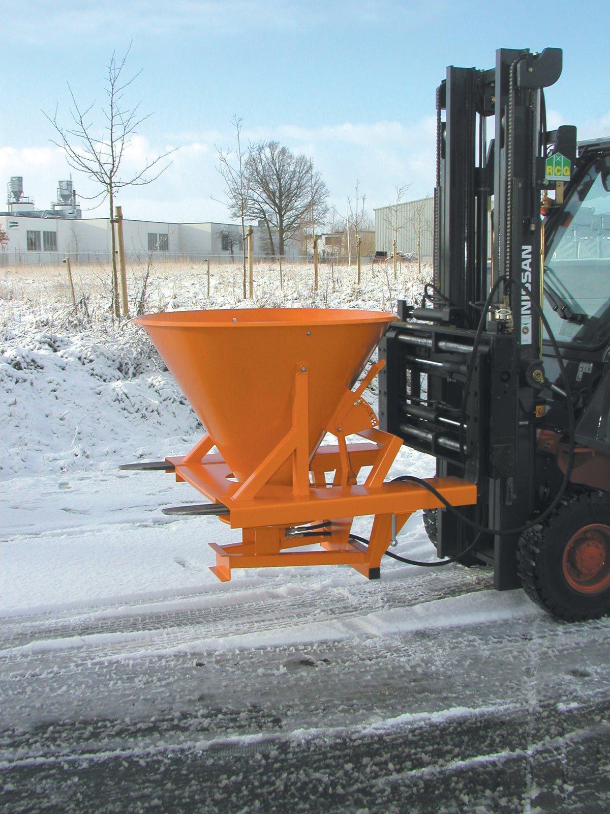Salt- och sandspridare monterad på gaffeltruck i miljö med snö och vinterväglag